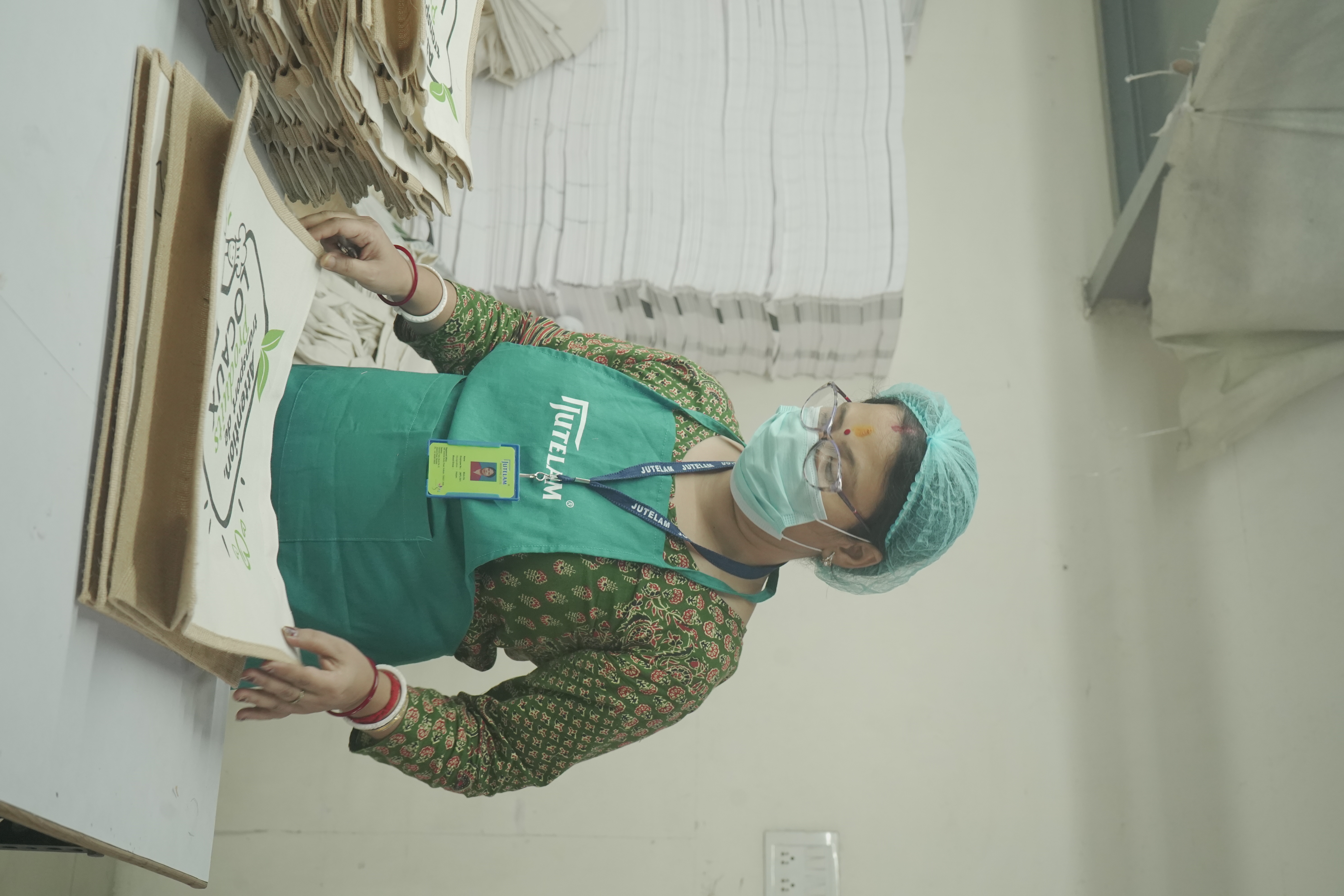 Worker inspecting finished printed jute bags