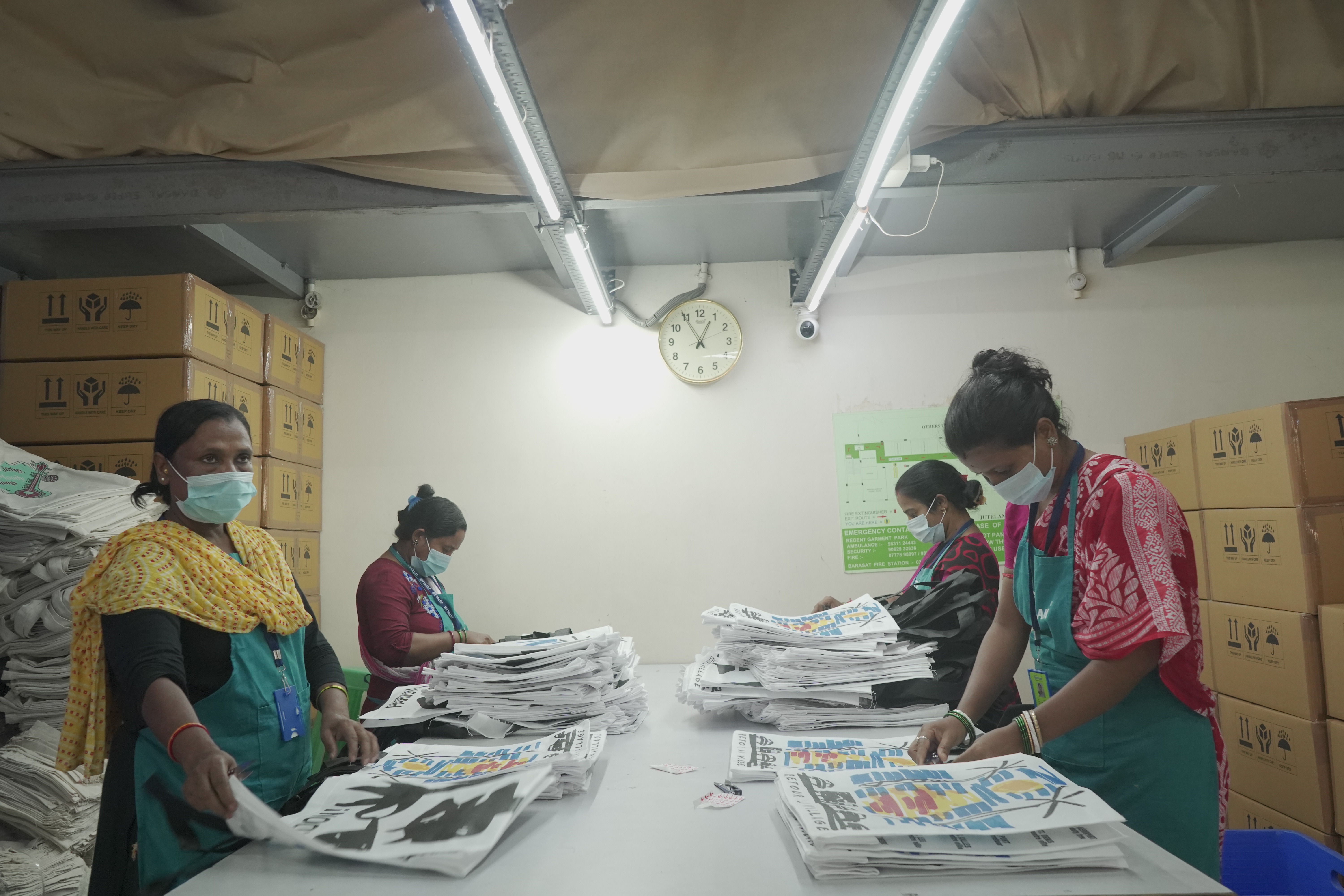 Team processing stack of printed bags